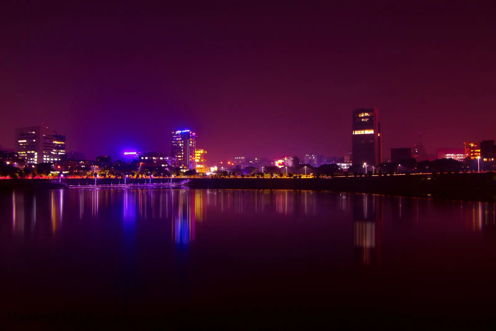 Dhaka at night, office towers reflected in the lake