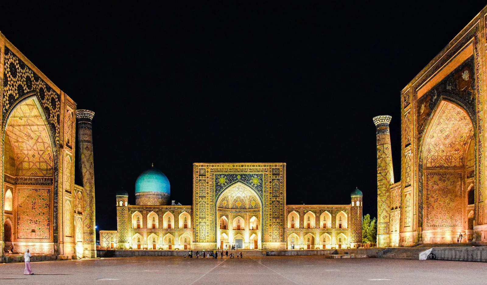 Registan Square in Samarkand at night, its three madrasas lit